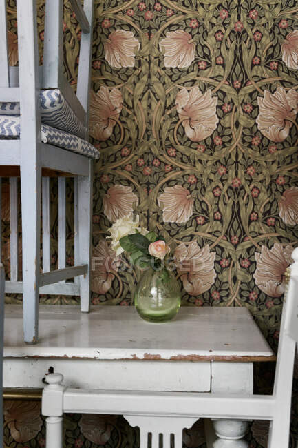 Красиві квіти в скляній вазі на білому дерев'яному старовинному столі — стокове фото