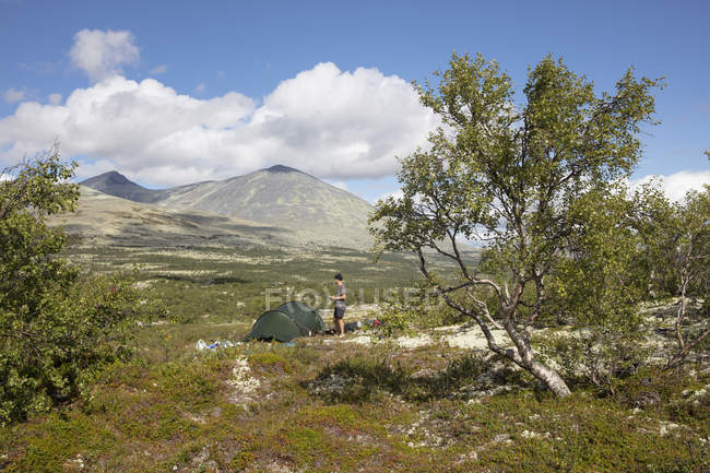 Homem por tenda no Parque Nacional Rondane, Noruega — Fotografia de Stock