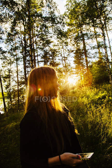 Junge Frau bei Sonnenuntergang im Wald — Stockfoto