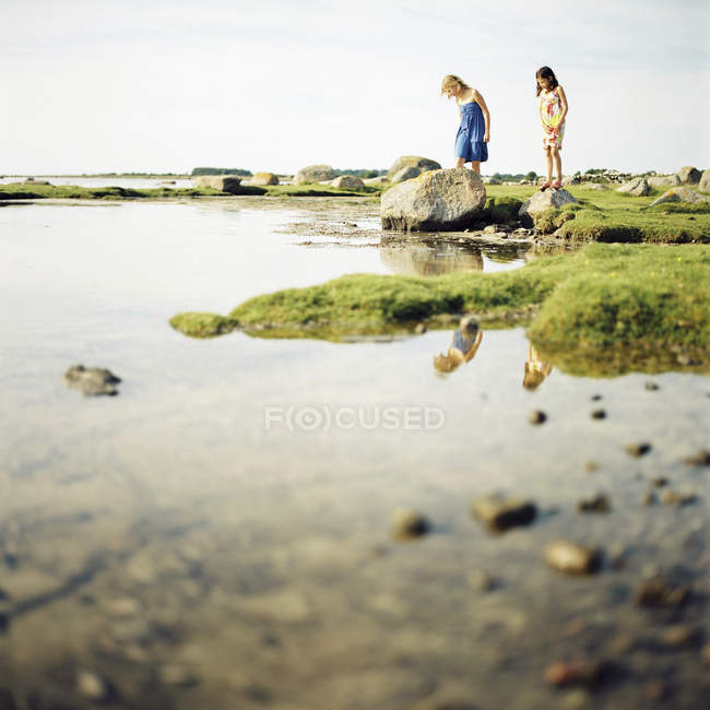 Two girls standing by lake, selective focus — Stock Photo