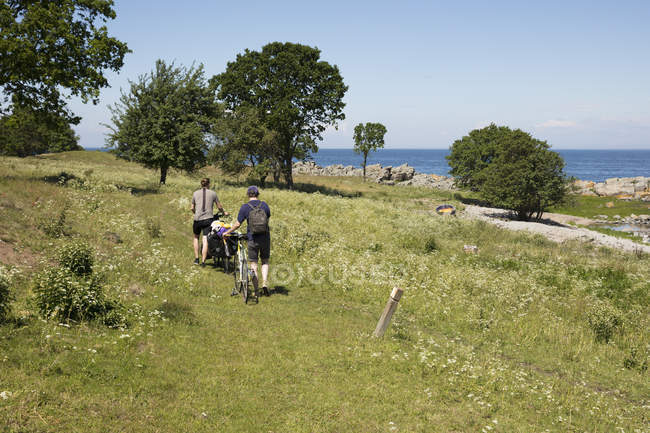 Men with bicycles in field, selective focus — Stock Photo