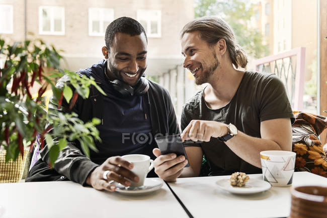 Young men sitting together in cafe — Stock Photo