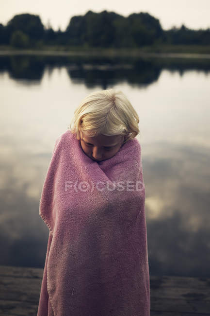 Girl wrapped in pink towel by lake — Stock Photo