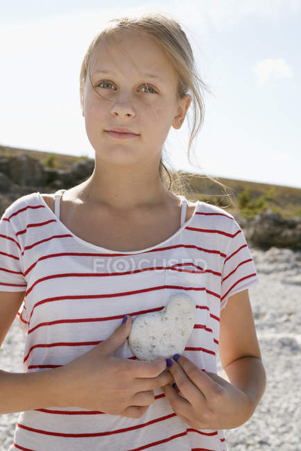 Menina com pedra forma de coração, foco seletivo — Fotografia de Stock