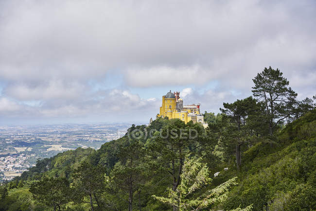 Pena Palace by trees en Sintra, Portugal - foto de stock