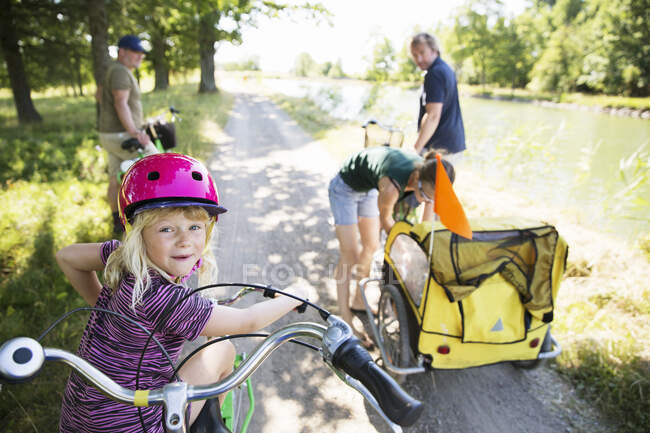 Family cycling by canal at sunny day — Stock Photo