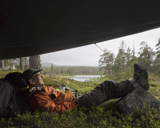 Человек, лежащий в палатке, избирательный фокус — стоковое фото