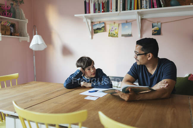 Батько допомагає своєму синові з домашнім завданням — стокове фото