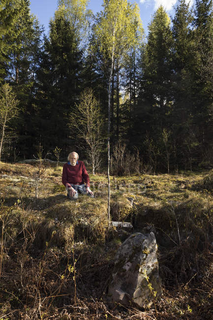 Senior man sitting in field, selective focus — Stock Photo