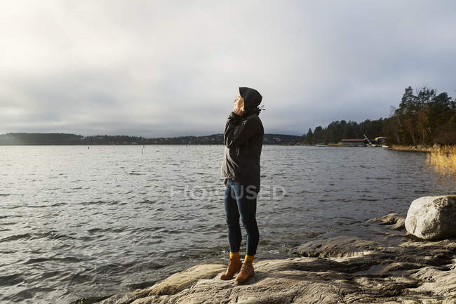 Young woman standing next to lake — Stock Photo