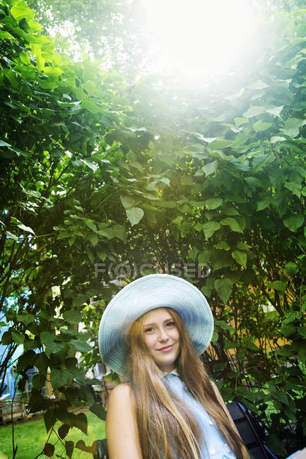 Retrato de menina adolescente em chapéu contra plantas — Fotografia de Stock
