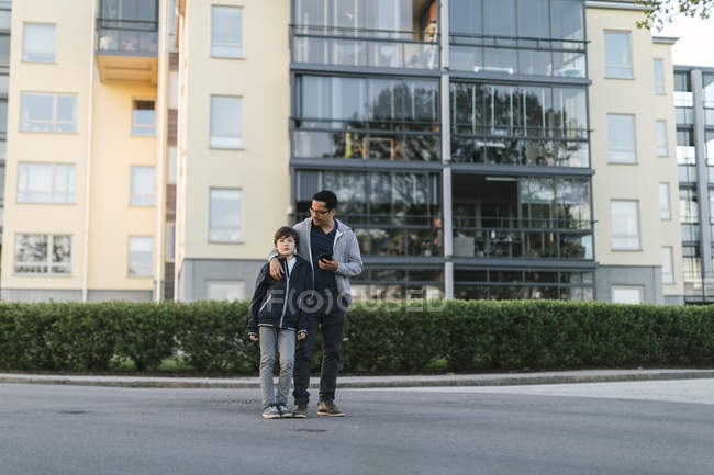 Pai com braço à volta do filho na cidade — Fotografia de Stock
