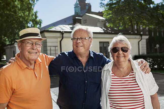 Портрет пожилых людей, стоящих вместе и улыбающихся в камеру — стоковое фото