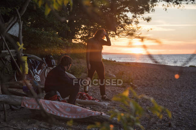 Чоловіки на пляжі під час заходу сонця, вибірковий фокус — стокове фото