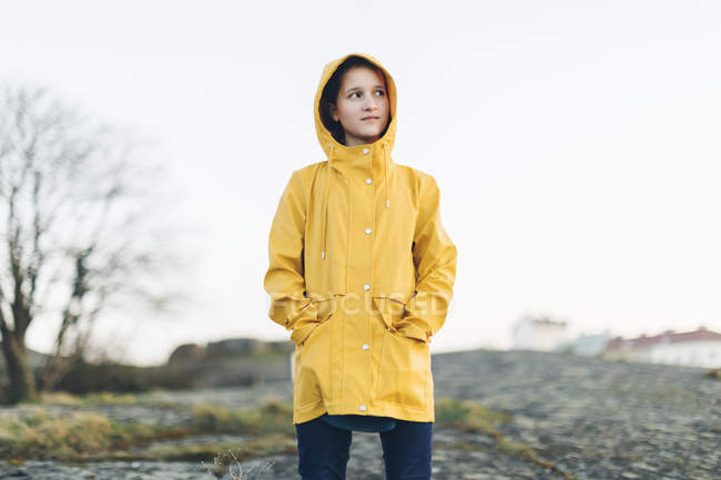 Fille portant un manteau jaune dans le parc — Photo de stock