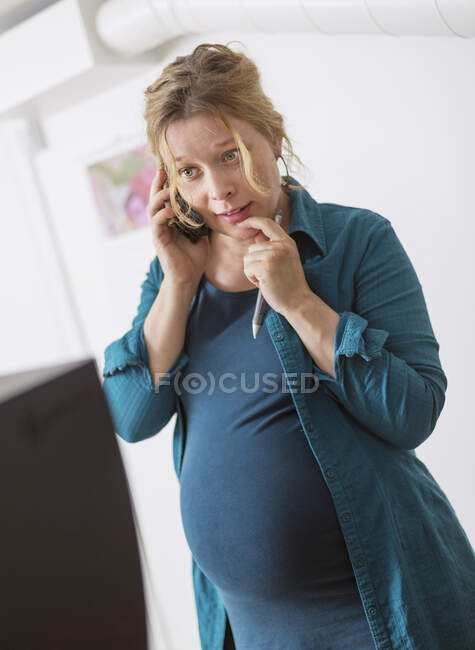 Mujer embarazadas que habla por teléfono inteligente - foto de stock