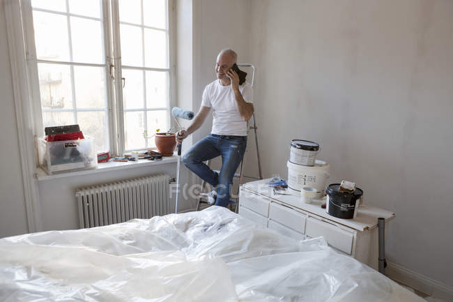 Mittlerer erwachsener Mann telefoniert bei Wohnungsrenovierung — Stockfoto