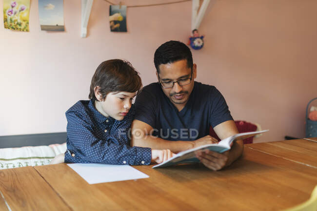 Батько допомагає своєму синові з домашнім завданням — стокове фото