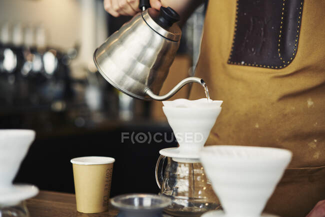Молодий бариста робить каву в кафе — стокове фото