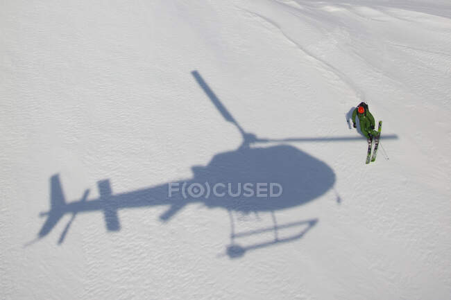 Erhöhter Blick auf Skifahrer und Helikopterschatten auf Schnee in Lappland, Schweden — Stockfoto