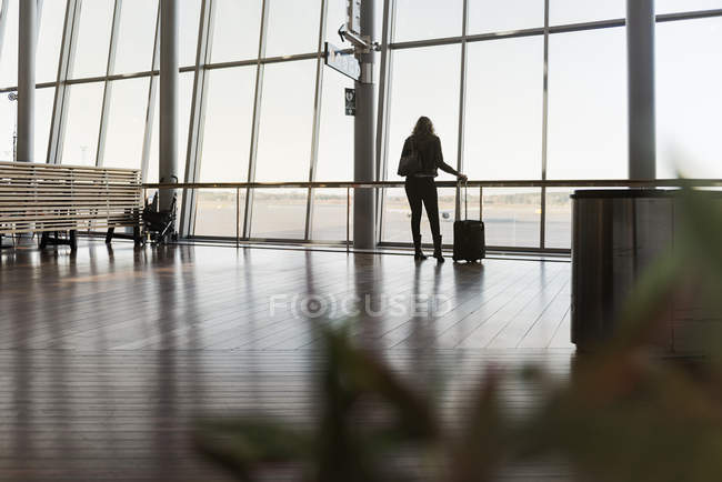 Woman with suitcase in airport, selective focus — Stock Photo
