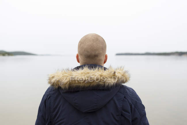 Чоловік дивиться на море, вид ззаду — стокове фото