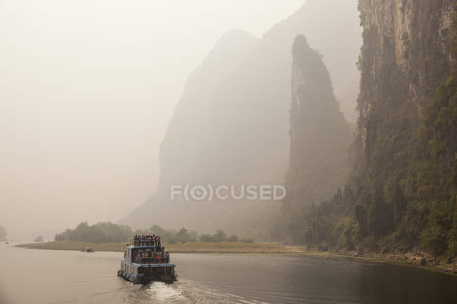 Personas que viajan en ferry en Sichuan, China - foto de stock