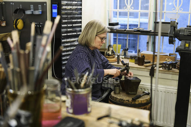 Goldsmith working at anvil, selective focus — Stock Photo