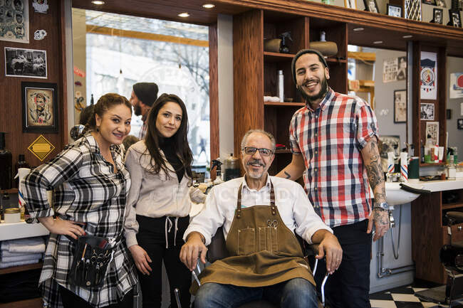 Portrait of barbers smiling at camera in barbershop — Stock Photo