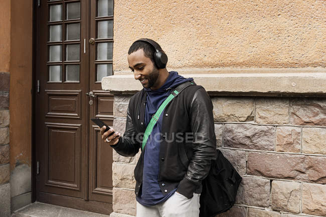 Молодий чоловік слухає музику на вулиці — стокове фото