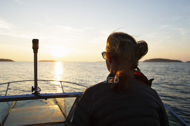 Жінка на човні на заході сонця, вибірковий фокус — стокове фото