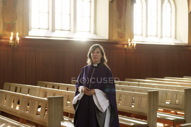 Retrato de sacerdote con túnicas púrpura en la iglesia, enfoque selectivo - foto de stock