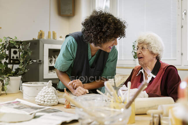 Senior woman making pottery at nursing home — Stock Photo