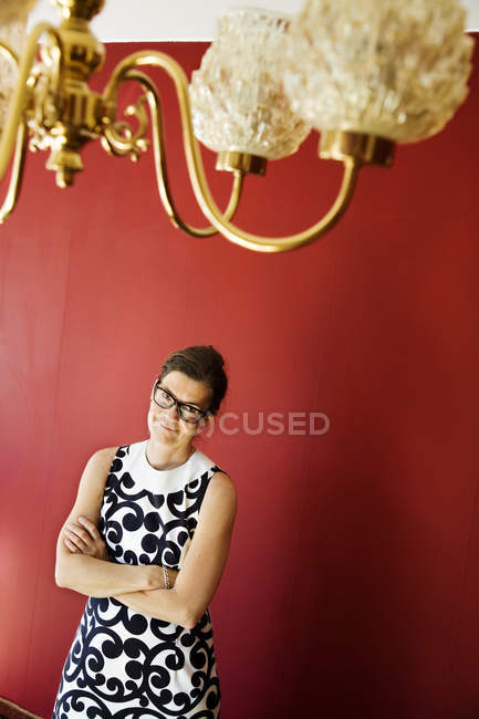 Portrait of mature elegant woman against red wall — Stock Photo
