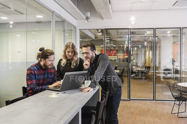 Coworkers looking at laptop, selective focus — Stock Photo