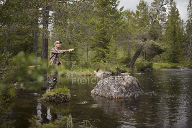 Человек рыбачит в реке, избирательный фокус — стоковое фото