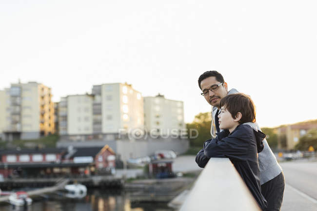 Father and son leaning on city railing — Stock Photo