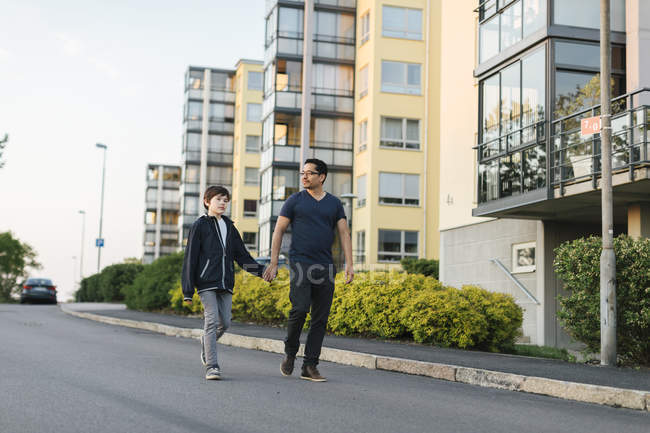 Pai e filho de mãos dadas na rua da cidade — Fotografia de Stock