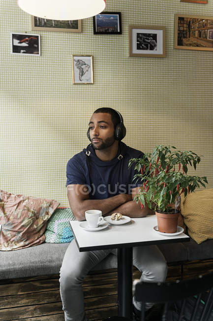 Young man listening to music in cafe — Stock Photo