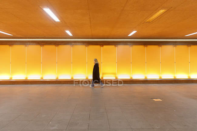 Mujer joven caminando por el paso subterráneo en el Aeropuerto de Arlanda, Suecia - foto de stock