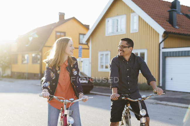 Couple cycling on suburban street — Stock Photo