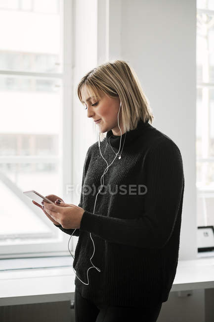 Woman using smart phone, focus on foreground — Stock Photo