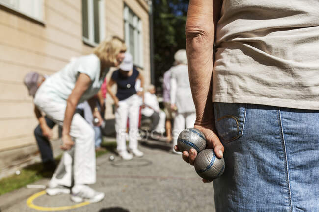 Seniors playing petanque outdoors, cropped shot, selective focus — Stock Photo