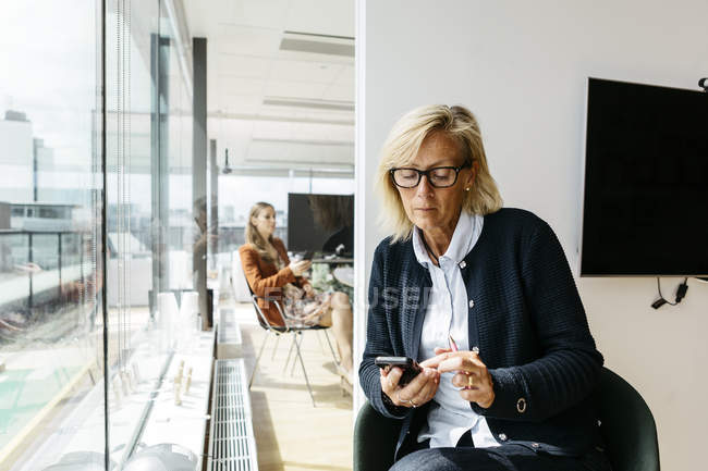 Donna d'affari che utilizza lo smart phone, concentrarsi sul primo piano — Foto stock