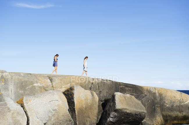 Mujeres caminando sobre rocas, enfoque selectivo - foto de stock