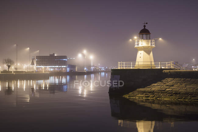 Lighthouse at harbor entrance in Malmo, Sweden at night — Stock Photo