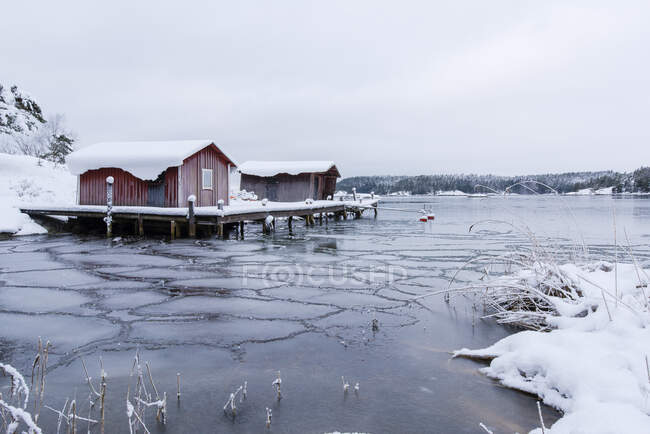Casas acima do lago congelado em Alback, Suécia — Fotografia de Stock