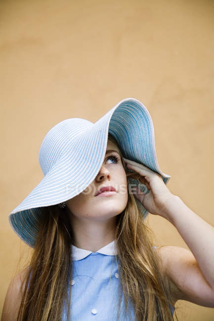 Teenage girl in blue hat against wall — Stock Photo