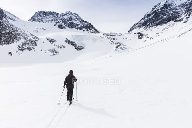 Mujer esquiando en la montaña Kenekaise en Laponia, Suecia - foto de stock