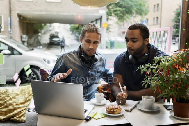 Young men working together in cafe, selective focus — Photo de stock